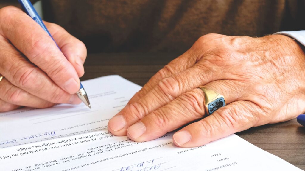 Persona mayor firmando un documento legal